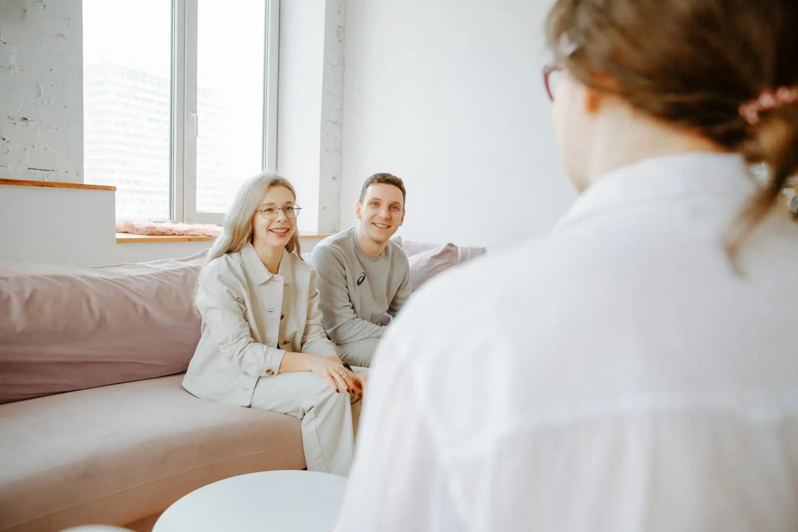 A psychologist and client talking together in a bright, comfortable consultation space.